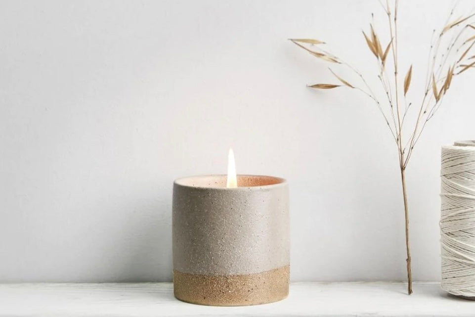 Single pot candle with lit flame
