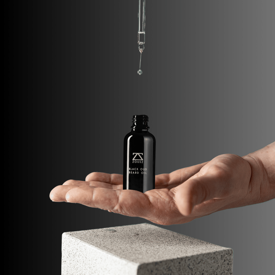 ZOUSZ Black Oud beard oil bottle with black dropper cap, featuring dark amber-colored oil in a clear glass container.