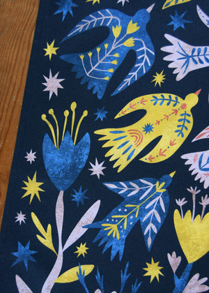 Colorful fabric pattern with birds and flowers on a dark background