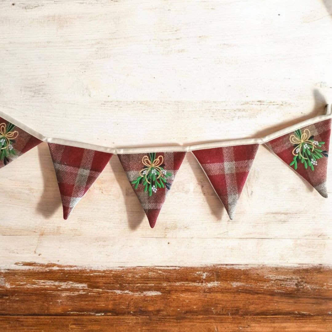 Decorative Christmas-themed banner with red and green designs on a wooden surface.