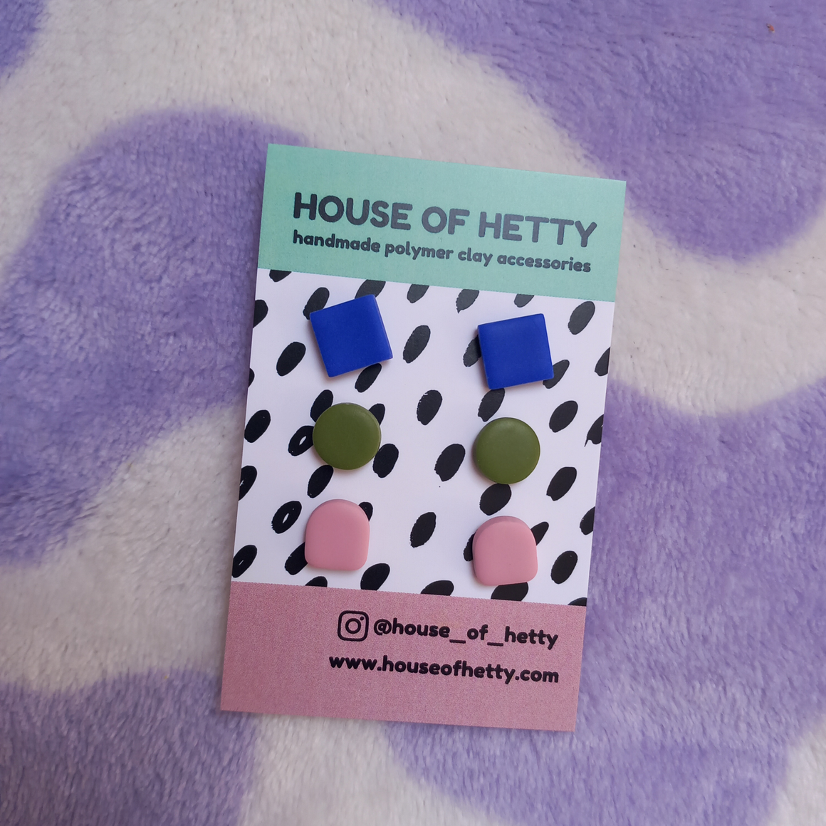 Packaged earrings with blue, green, and pink colors on a polka dot card with 'House of Hetty' branding.