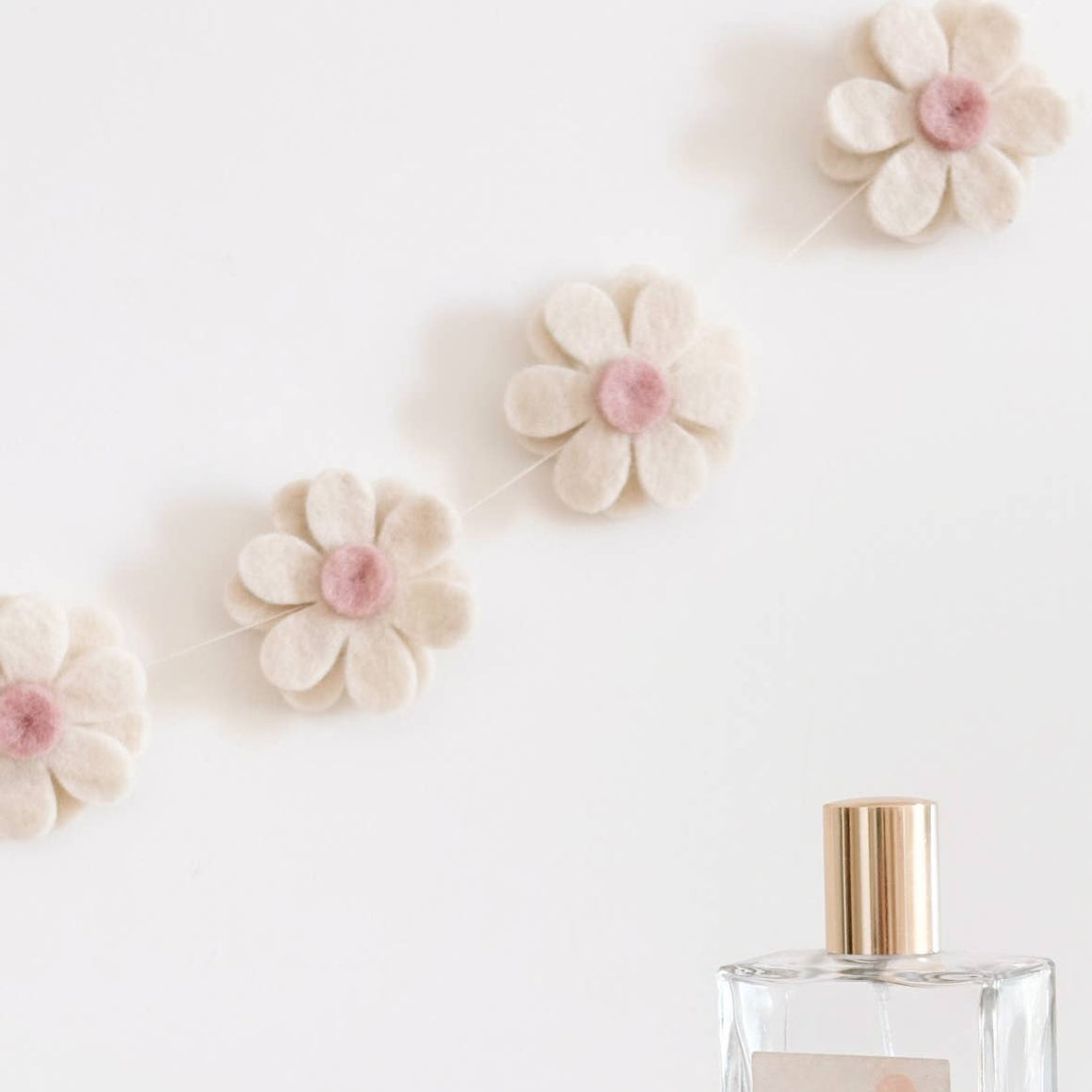 Perfume bottle with flowers and a basket on a light background