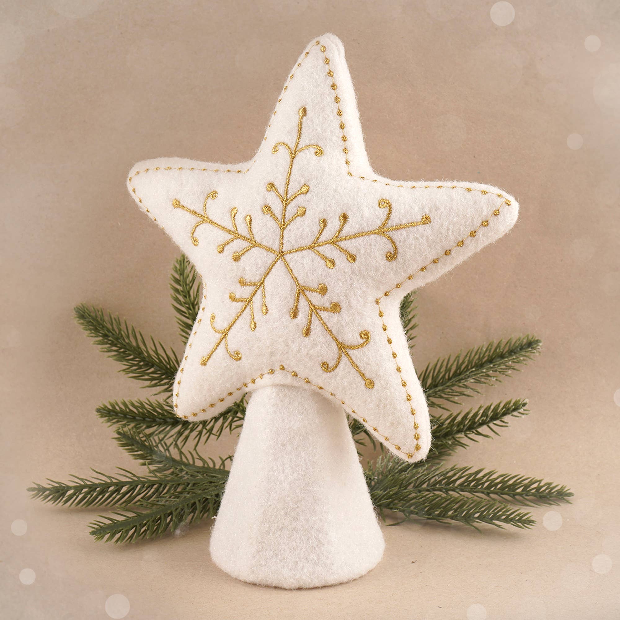 Decorative star ornament with gold embroidery on a beige background