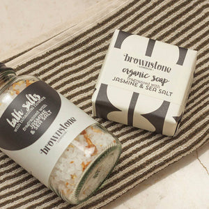 Brownstone bath salts and organic soap on a striped surface