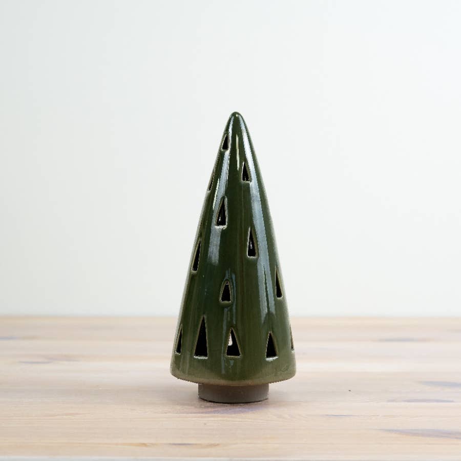 Green ceramic incense cone on a wooden surface with a light gray background