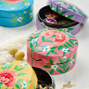 Colorful floral-patterned jewelry boxes on a light background