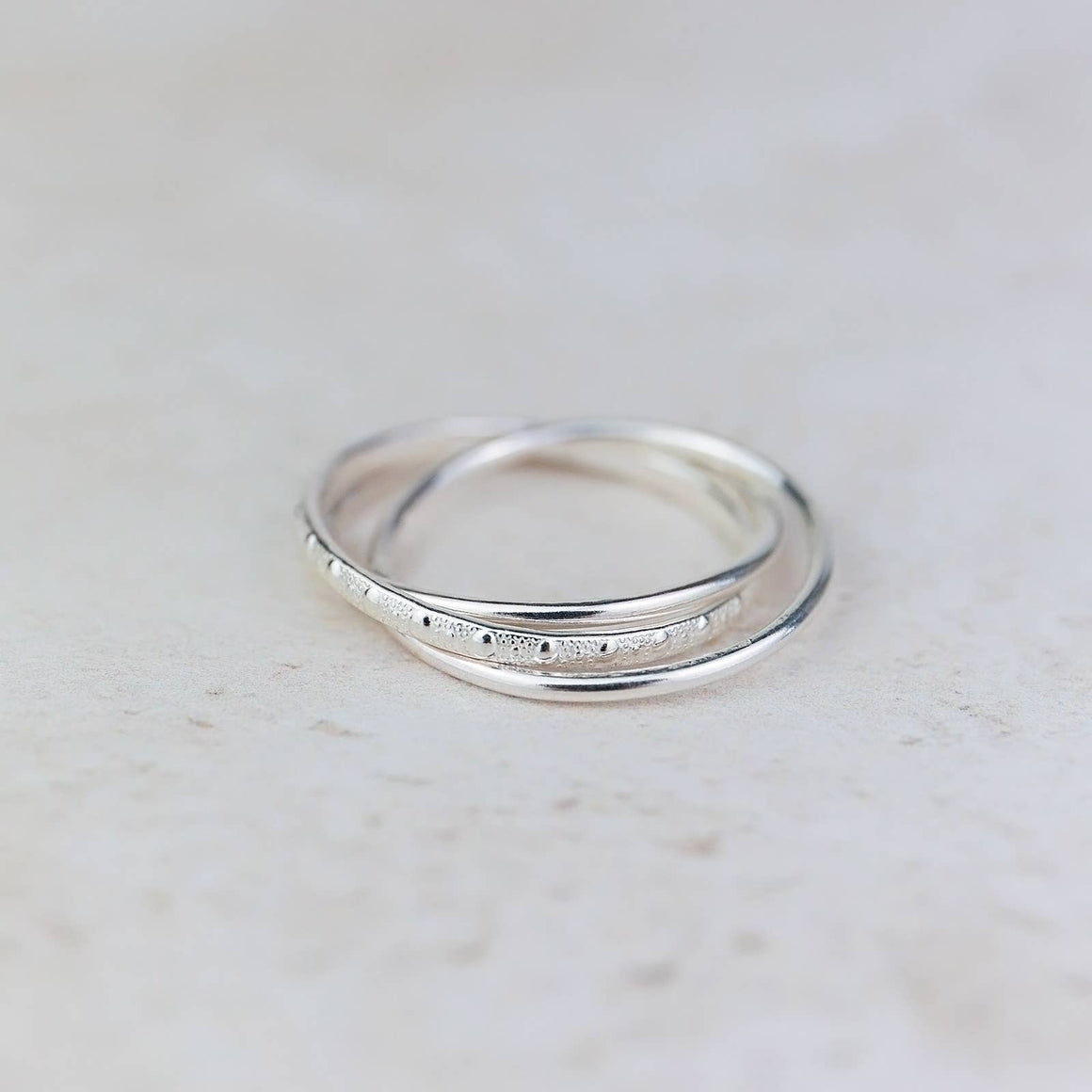 Sterling silver triple ring by Lucy Kemp Jewellery with three interconnected bands, medium size, stylish and elegant jewelry piece.