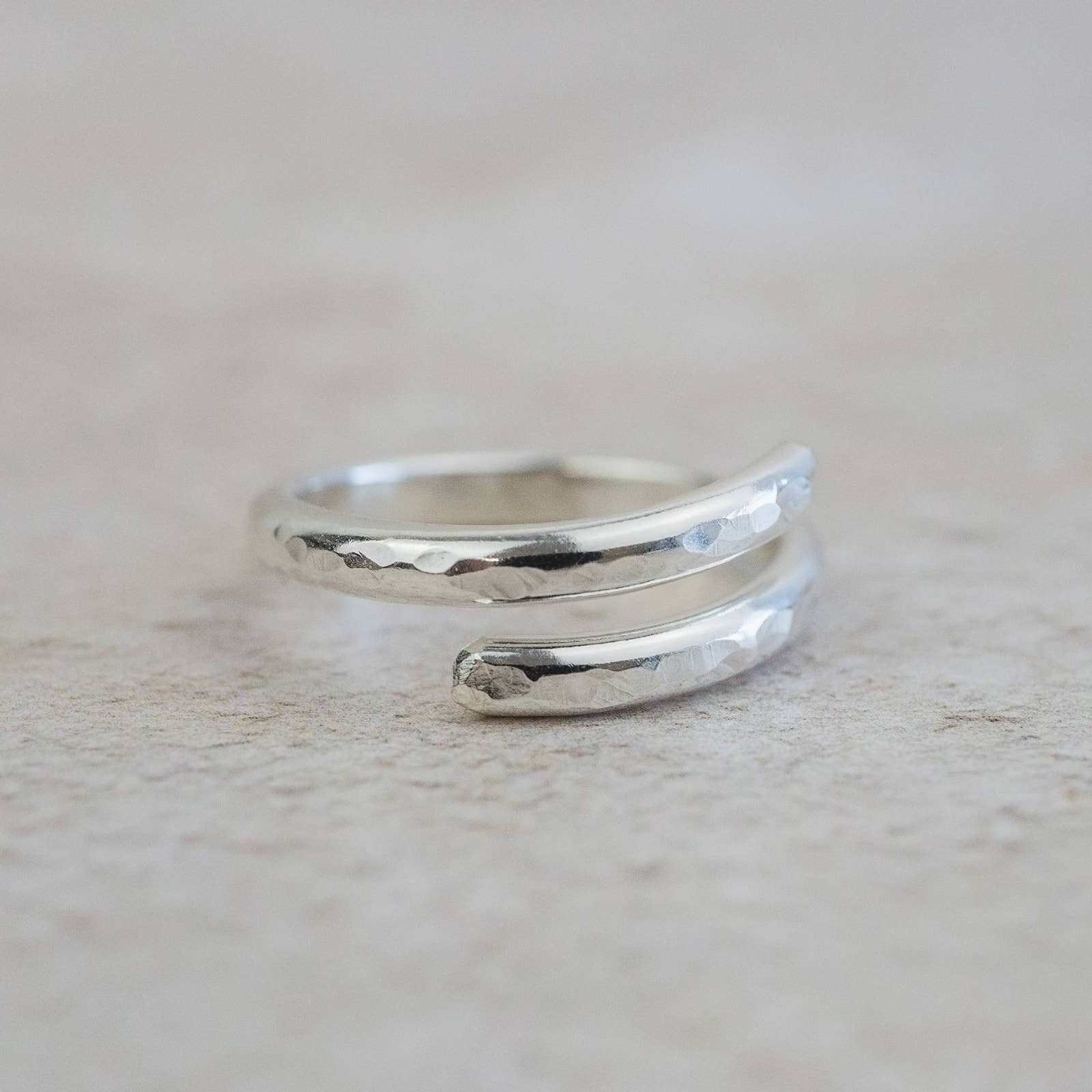 Silver ring with a textured design on a light gray background