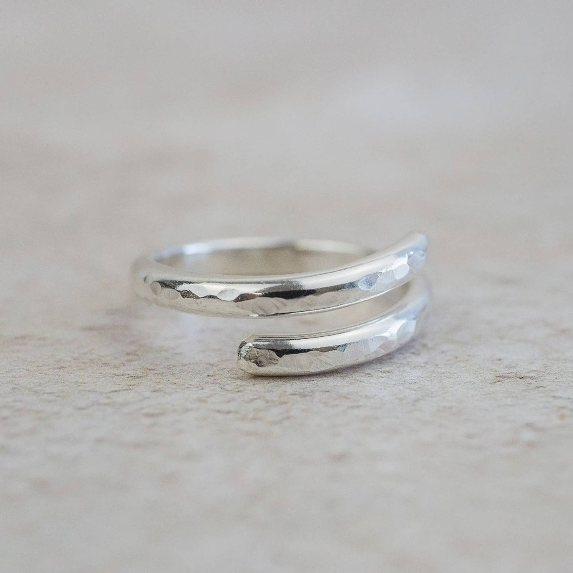Silver ring with a textured design on a light gray background