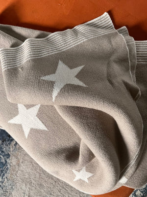 Gray fabric with white star patterns on a textured surface