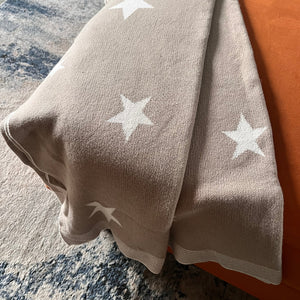 Beige fabric with white star patterns on a textured surface