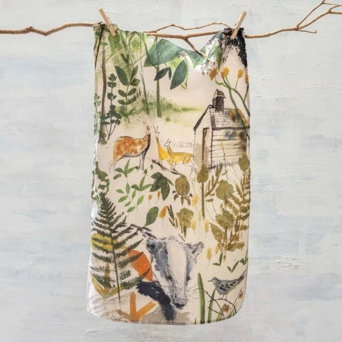 Nature-themed fabric with animals and plants hanging on a branch against a light background