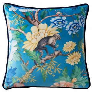 Decorative pillow with floral and monkey design on a blue background
