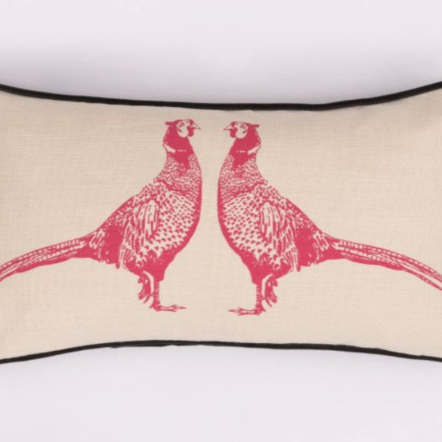 Two decorative pillows on a wooden bench with a green and white tiled wall in the background.