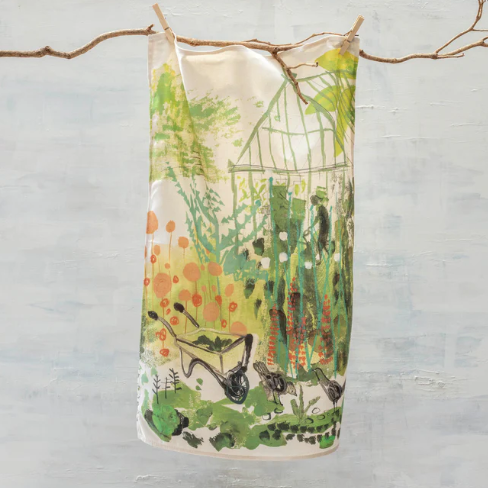 Decorative towel with nature-themed design hanging on a branch against a light gray background