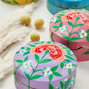 Colorful round boxes with floral designs on a light background