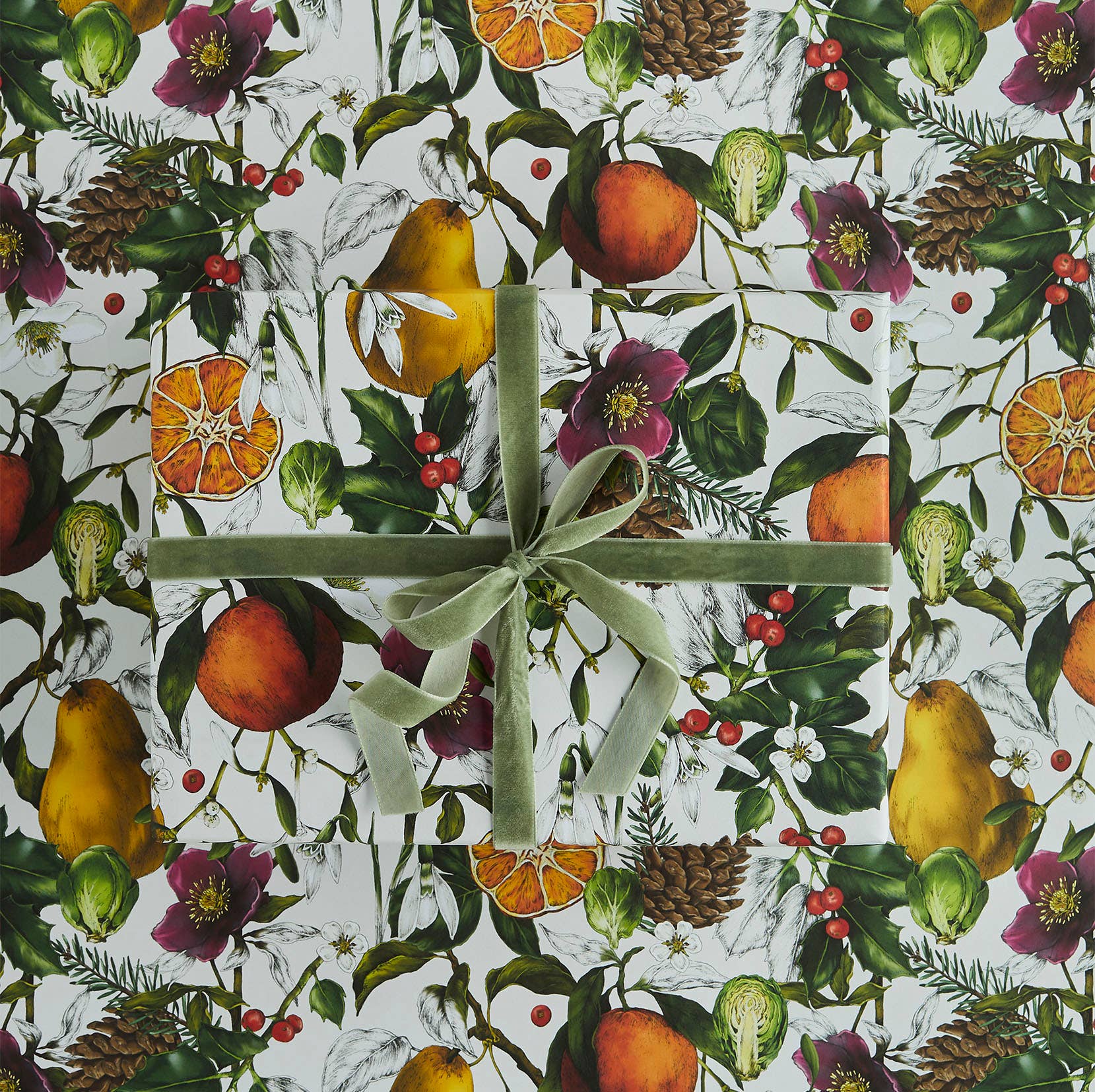 Gift wrapped in a decorative paper with fruits, flowers, and leaves on a white background