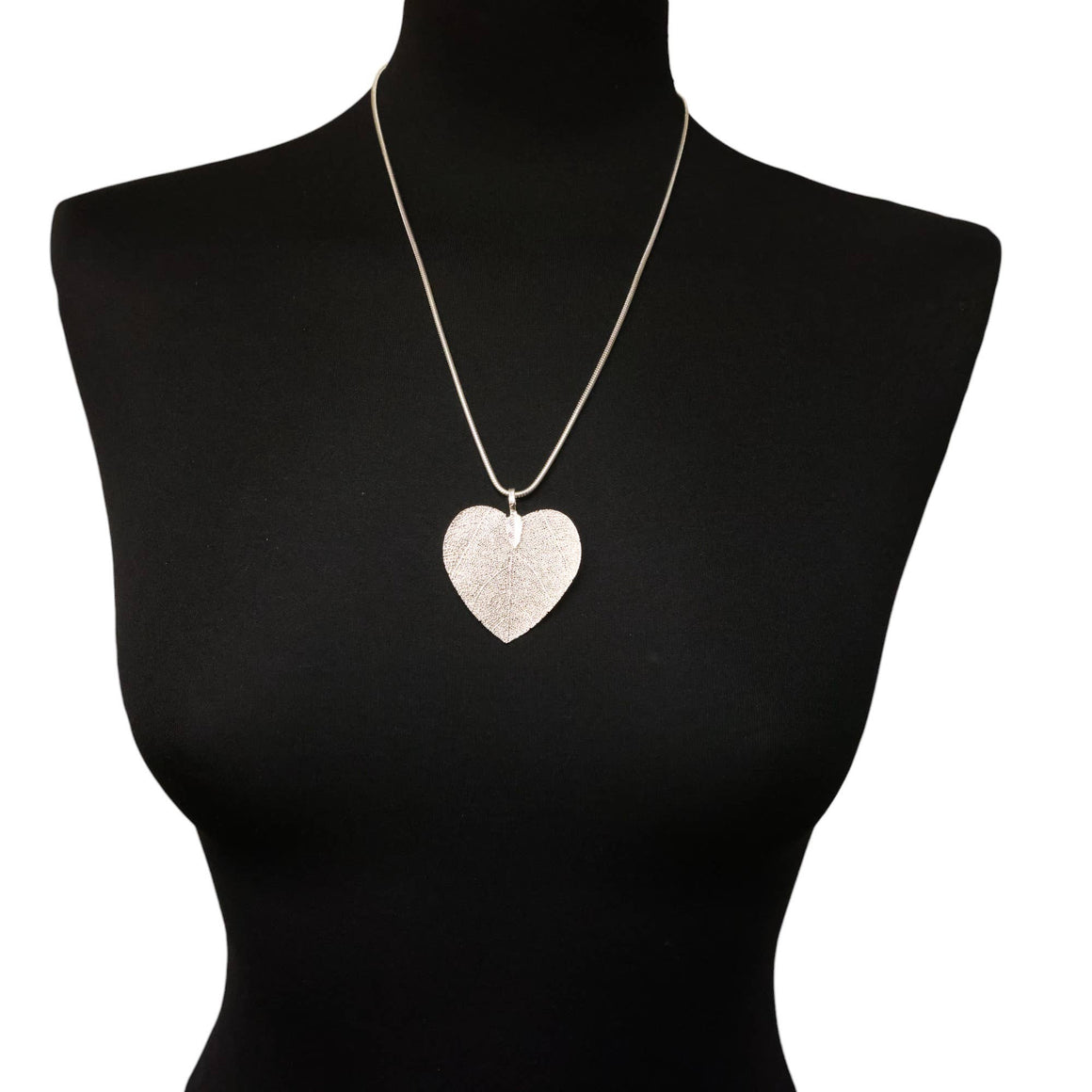 Heart-shaped pendant necklace on a black mannequin with a white background