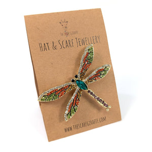 Dragonfly-shaped brooch on a 'Hat & Scarf Jewellery' card with a white background