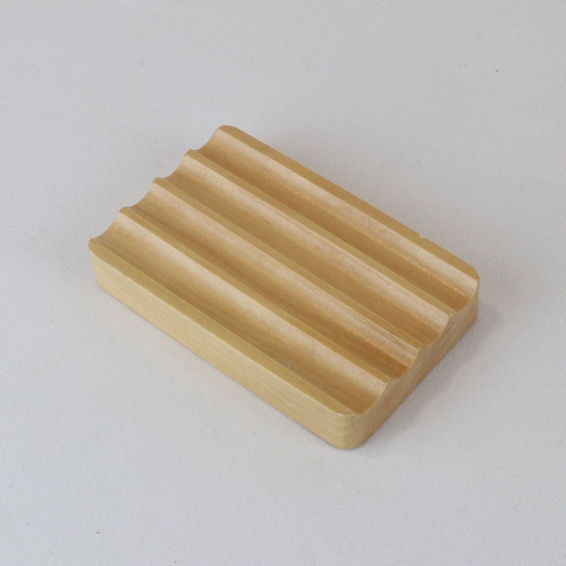 Pattern of wooden soap dishes with grooves on a white background