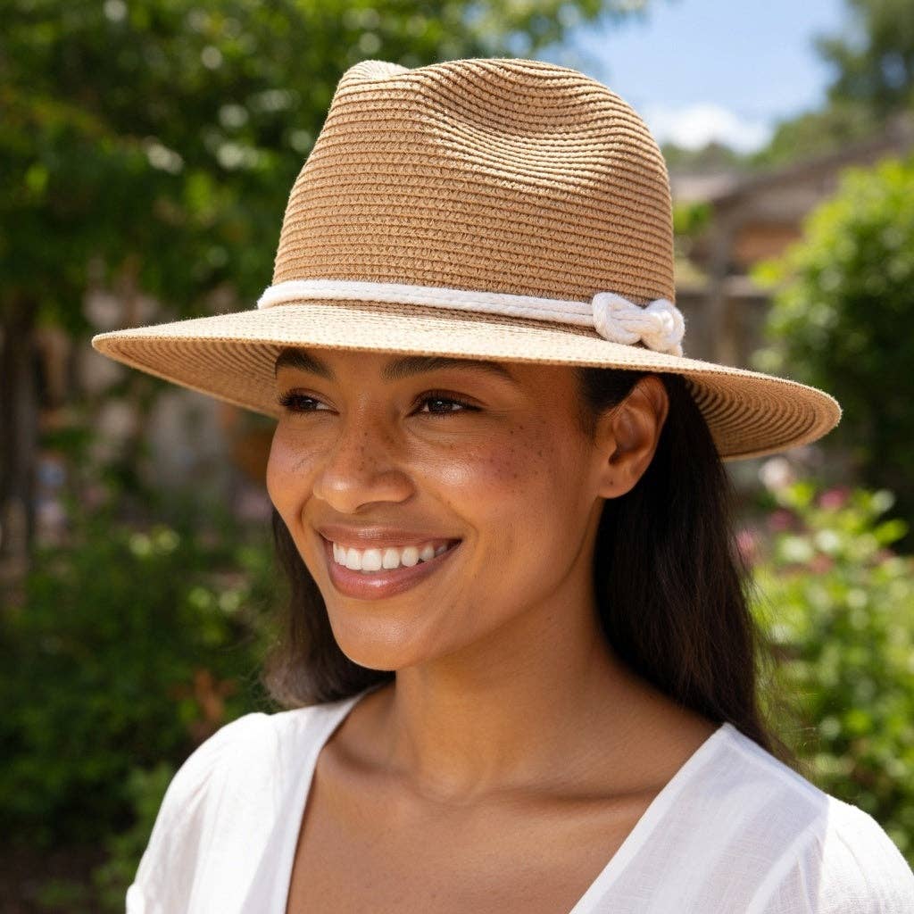 Woman wearing a straw hat with a white band outdoors