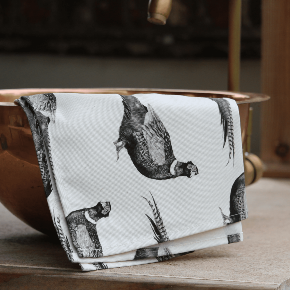 Copper bowl with a black and white patterned napkin on a wooden surface