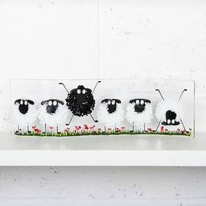 Decorative wall art with black sheep and a white background