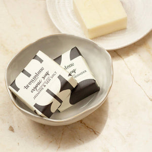 Two bars of soap in a bowl on a marble surface