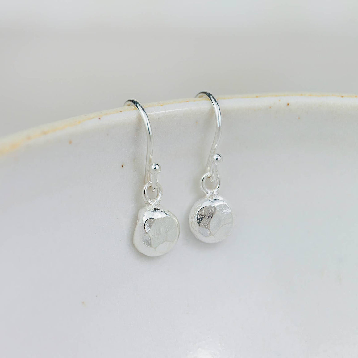 Handmade sterling silver recycled nugget drop earrings by Lucy Kemp Jewellery with organic textured design.