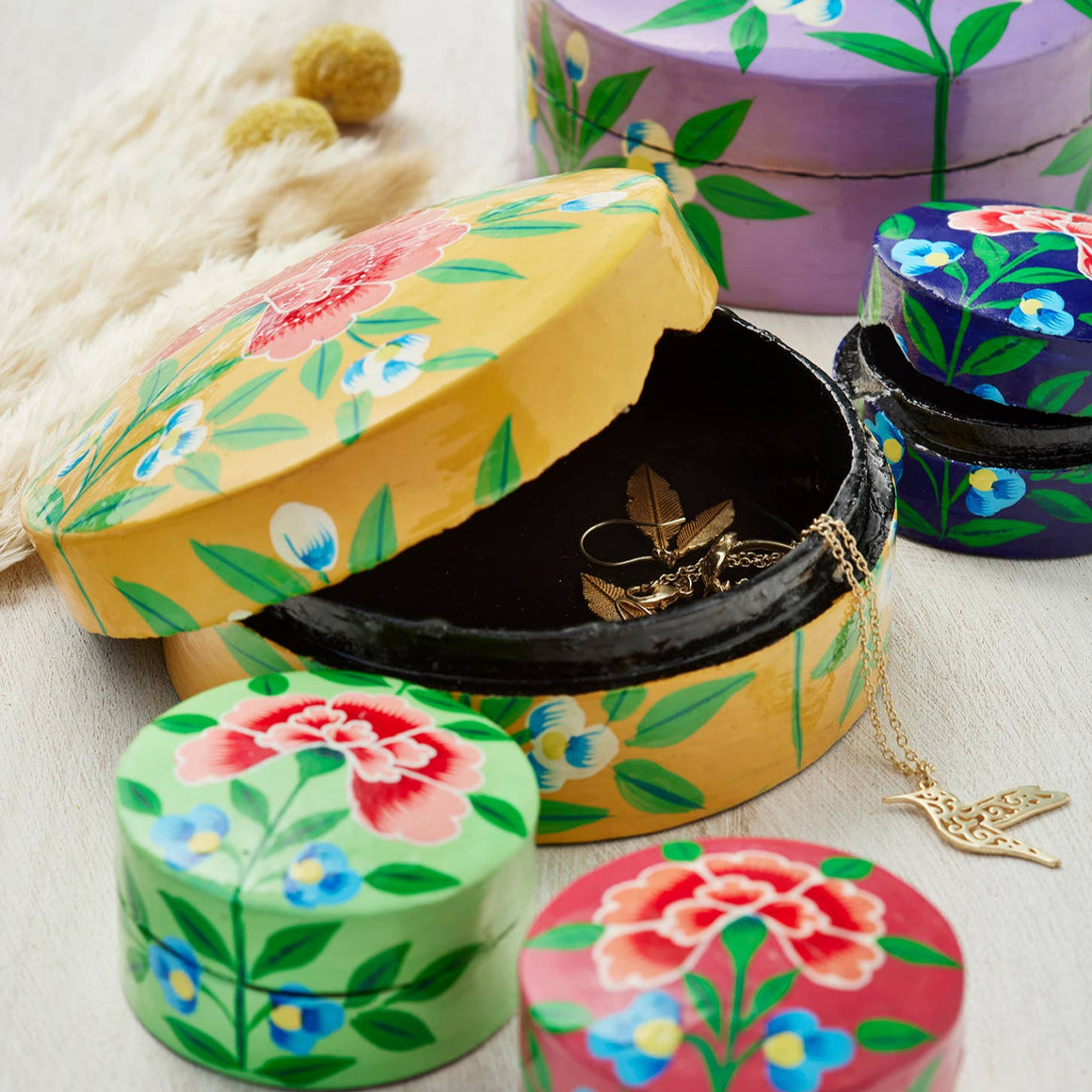 Colorful floral-patterned jewelry boxes on a light background